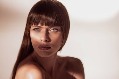 Uçsuz bucaksız bir kadın yüzü ve dramatik bir gölge yoğun bir hava yaratıyor. Güzellik kavramı, editoryal portre, cilt bakımı, kişisel bakım, moda minimalizmi ve duygusal ifade.