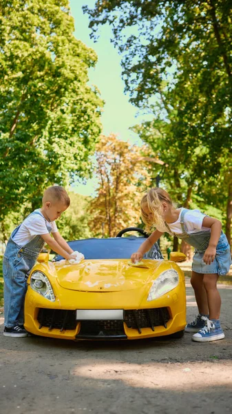 : Çocuklar Sunny Park 'ta oyuncak sarı araba kaputunu beraber yıkıyorlar. Takım çalışması kavramı, oyuncu sorumluluk, açık hava yaşam tarzı ve eğlenceli aktivitelerle bağ kurma..