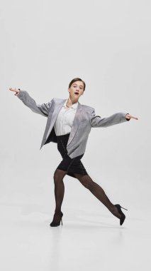 Gümüş ceketli enerjik kadın dans ederken dinamik bir hareketle poz veriyor. Özgürlük kavramı, eski moda, bireysellik, hırs ve kendini ifade etme..