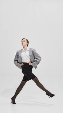 Gümüş ceketli, güçlü yürüyüş pozu veren kendine güvenen bir iş kadını. Liderlik kavramı, kariyer hırsı, güç ve cesur kurumsal yaşam tarzı..