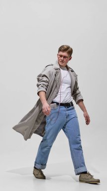 Trençkotlu, kasetçalar ve retro gözlüklü şık bir adam. Eski moda, güven, yaşam tarzı ve şehir nostaljisi kavramı.