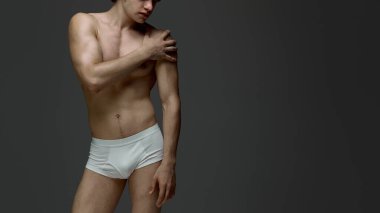 Beyaz iç çamaşırlı, omuz omuza duran erkek figürü. Anatomi görselleştirme, vücut farkındalığı, erkek sağlık hizmetleri ve moda markalaşması kavramı.