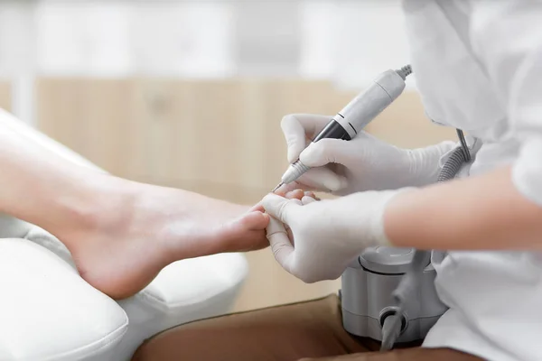 Doctor in de handschoenen maken van de procedure voor voet met speciale apparatuur. — Stockfoto