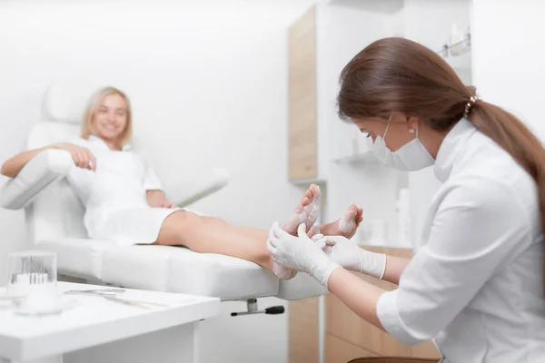 Vrouwelijke arts podoloog maken procedure van massage en peeling. — Stockfoto