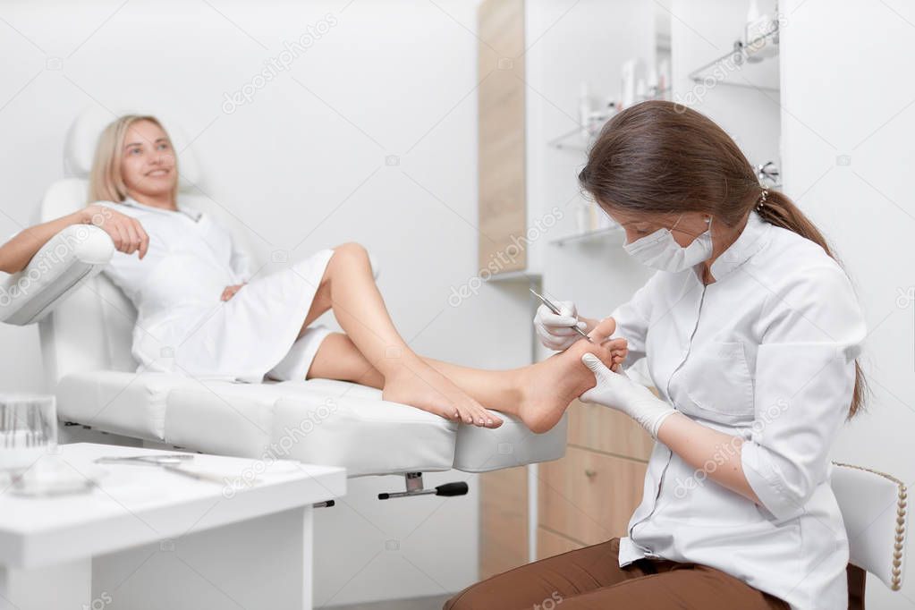 Podiatrist doctor cleaning foot from callus.
