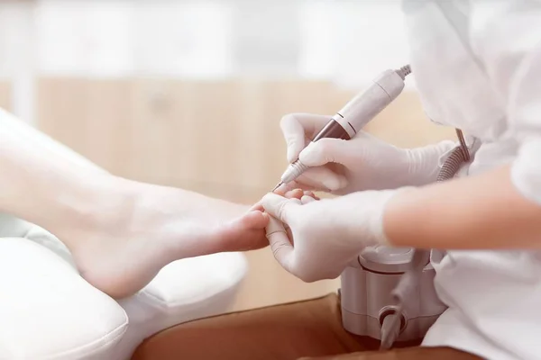 Doctor in de handschoenen maken van de procedure voor voet met speciale equipmen — Stockfoto