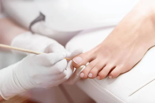 Especialista en salón de belleza haciendo pedicura francesa para cli hembra — Foto de Stock