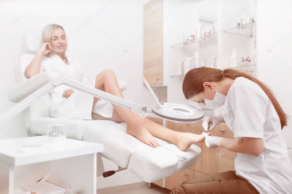 Podiatrist making procedure for client foot with special equipme