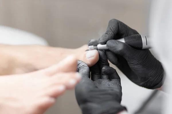 Médecin en gants faisant la procédure pour le pied avec un équipement spécial . — Photo