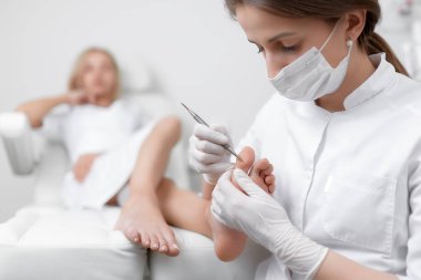 Ayak hastalıkları uzmanı Doktor istemci ayak özel demir aracı ile ilgili bakım.