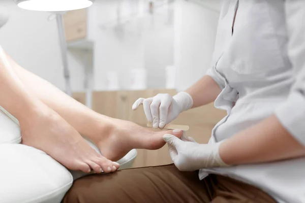 Médico en guantes procedimiento para el pie con equipo especial . —  Fotos de Stock