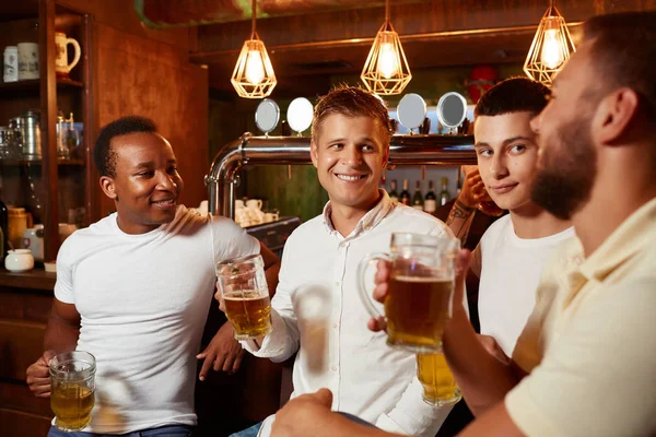 Company of four handsome men listening carefully story of one of men. — Stock Image Company of four handsome men listening carefully story of one of men. Stock Photo