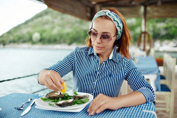 Mulher comendo uma ostra delicadeza, close-up restaurante ao ar livre — Fotografia de Stock