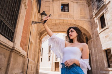 Güzel genç esmer selfie duran eski İspanya Valencia sokak yarışlarına son vereceğine Smartphone kullanarak