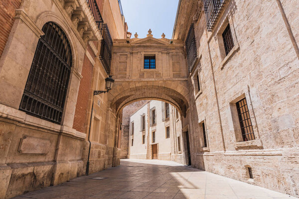Beautiful view of tiled path and arch on street of Valencia on sunny day