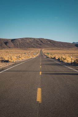 Mavi gökyüzü arka plan üzerinde Death Valley California uzun Asfaltlı yol görünümünü