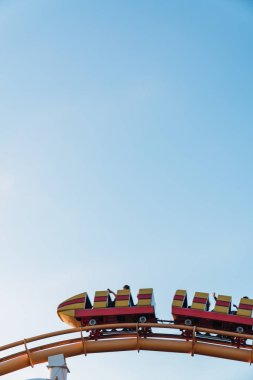 Santa Monica pier, Los Angeles, Kaliforniya mavi gökyüzü arka plan üzerinde kişi ile aşağıdan parlak lunapark treni