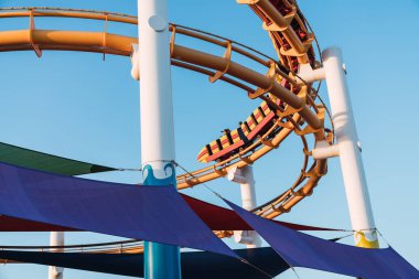 Santa Monica pier, Los Angeles, Kaliforniya mavi gökyüzü arka plan üzerinde içinde aşağıdan parlak lunapark treni