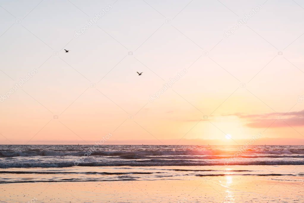 View of ocean with beautiful sunset in Santa Monica pier, Los Angeles, California on bright sky background 