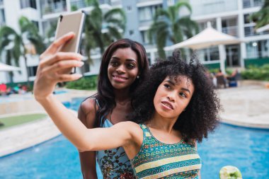 Modern genç Afro-Amerikan kadın selfie telefon konumu olan yaz aylarında havuz alarak