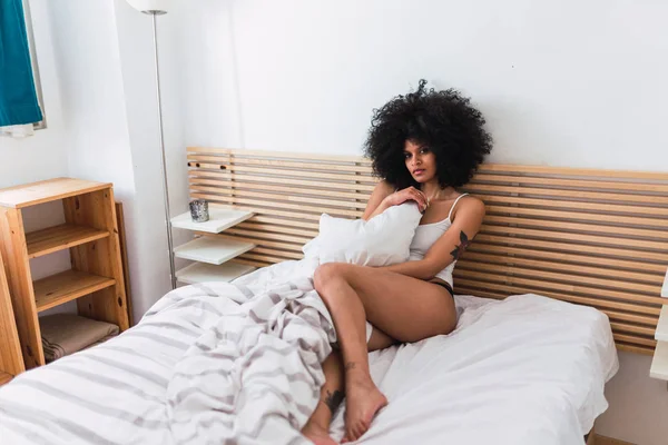 Jovem mulher negra sensual em lingerie deitada na cama — Fotografia de Stock