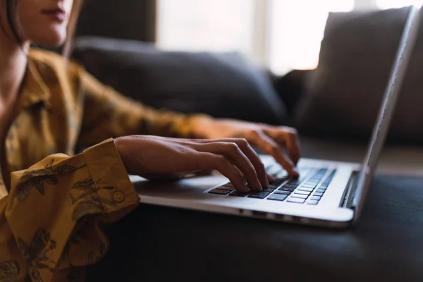 Wanita muda menggunakan laptop di sofa — Stok Foto