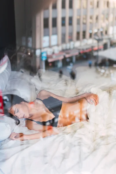Wanita muda dalam lingerie tidur di tempat tidur — Stok Foto