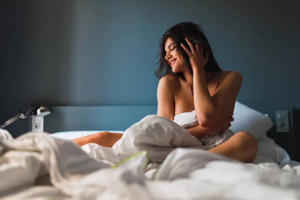 寝室のベッドの上に座って布団で目を閉じてスリム情熱的な陽気な裸の女性 — ストック写真