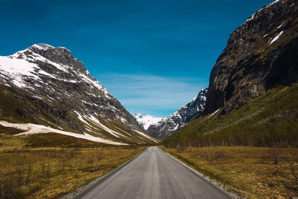 Empty straight road running between hilly picturesque rocks