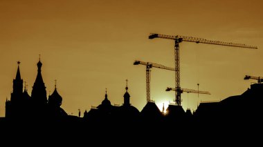 Kızıl Meydan kuleleri ve gün batımında Moskova'da İnşaat vinçleri kıvrımlarına