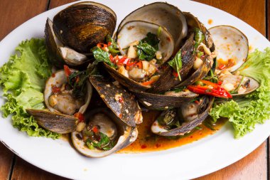 Tayland usulü midyeler acılı sarımsak ve fesleğenle kızartılır.