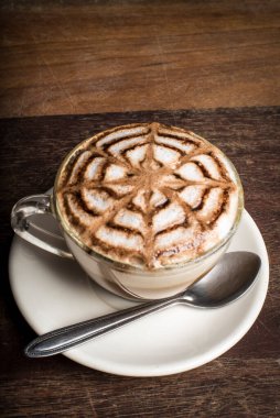 Üstünde güzel bir tasarım olan kapuçino.