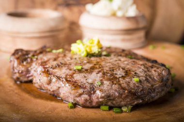 Biftek, patates püresi ve tereyağlı sos ile servis edilir.