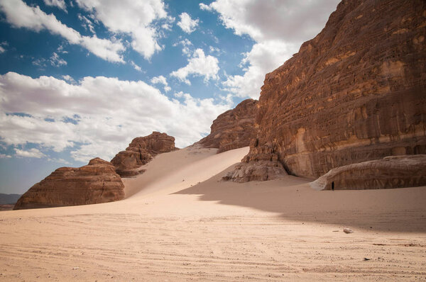 Desert landscape with blue sky and sun with sand and mountains