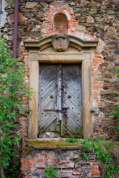 Vecchia porta in legno in un muro di mattoni Foto Stock Royalty Free