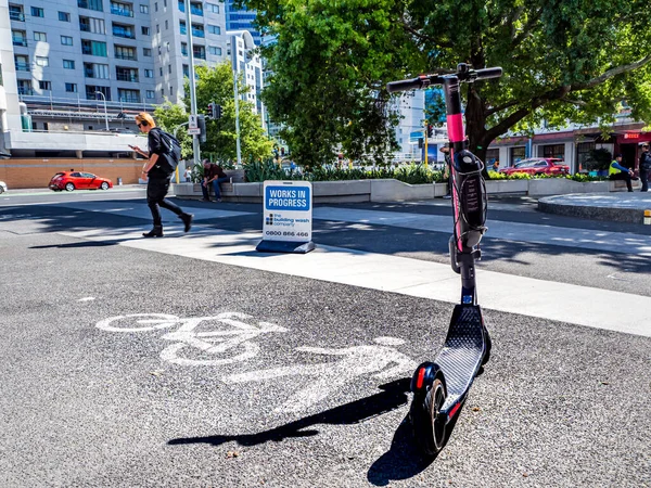 Auckland, Yeni Zelanda 10 Şubat 2020: Yürüyen birinin yanında elektrikli scooter ve bisiklet tabelaları