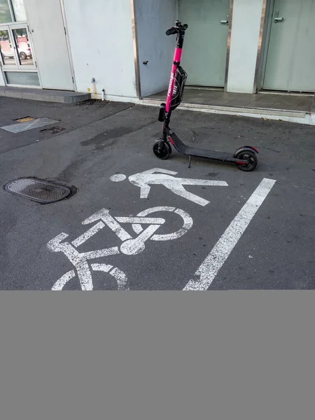 Auckland, Yeni Zelanda 10 Şubat 2020: Yayaların yanında elektrikli scooter ve arka planda duvar olan bisiklet tabelaları