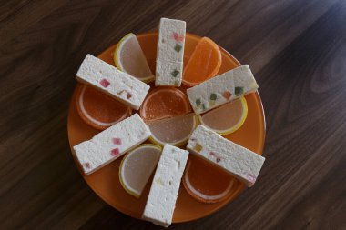 Limonlu marmelat ve portakal dilimleri. Lokum çubukları ve pastila tabakta.
