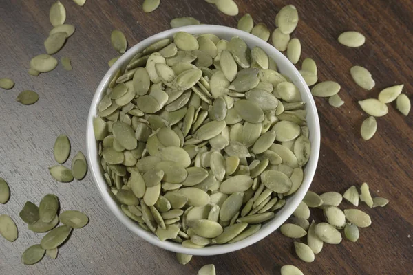 Vegan Food Raw Pumpkin Seeds Roasting White Dish Wooden Background — Stock Photo, Image