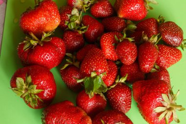 Taze toplanmış çilekler. Yeşil arkaplanda yakın plan
