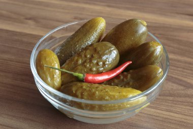 Ahşap arka planda kırmızı biberli salatalık turşusu. Lezzetli atıştırmalıklar, vejetaryen yemekleri..