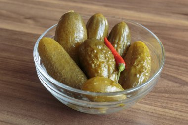 Ahşap arka planda kırmızı biberli salatalık turşusu. Lezzetli atıştırmalıklar, vejetaryen yemekleri..