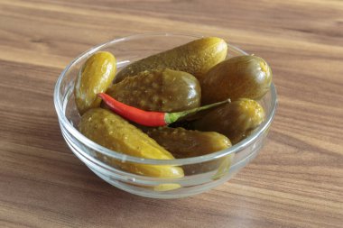 Ahşap arka planda kırmızı biberli salatalık turşusu. Lezzetli atıştırmalıklar, vejetaryen yemekleri..