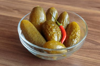 Ahşap arka planda kırmızı biberli salatalık turşusu. Lezzetli atıştırmalıklar, vejetaryen yemekleri..