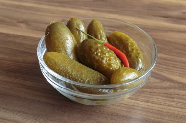 Ahşap arka planda kırmızı biberli salatalık turşusu. Lezzetli atıştırmalıklar, vejetaryen yemekleri..