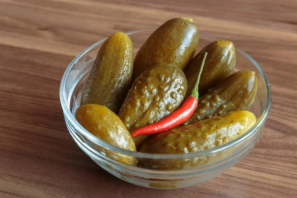 Ahşap arka planda kırmızı biberli salatalık turşusu. Lezzetli atıştırmalıklar, vejetaryen yemekleri..