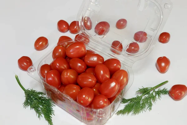 Cherry tomatoes in a plastic packaging on a white background, ready to sell, Vegan food. Business concept.