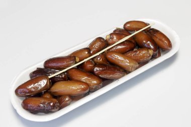 Hurmalar, plastik kutuya doldurulmuş, satılmaya hazır, beyaz arka plan. İş konsepti. Yakın plan..