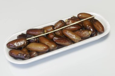 Hurmalar, plastik kutuya doldurulmuş, satılmaya hazır, beyaz arka plan. İş konsepti. Yakın plan..