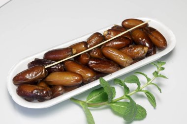 Hurmalar, plastik kutuya doldurulmuş, satılmaya hazır, beyaz arka plan. İş konsepti. Yakın plan..